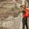 Photo of a hiker capturing the view over the bridge in Annapurna Range on Himalayas Nepal