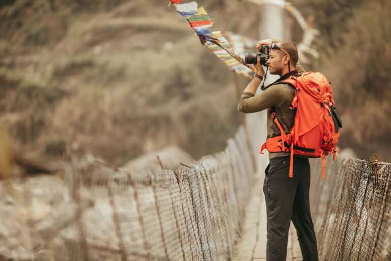 Photo of a hiker capturing the view over the bridge in Annapurna Range on Himalayas, Nepal